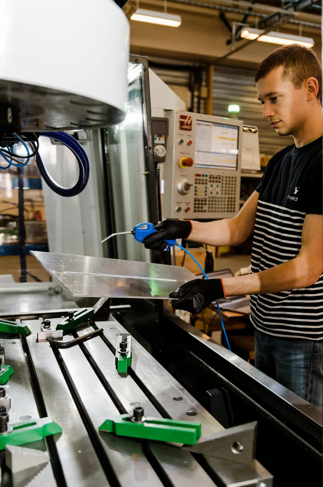 Un membre de l’équipe Stirweld tient le prototype d’une pièce en aluminium qu’il vient de souder.