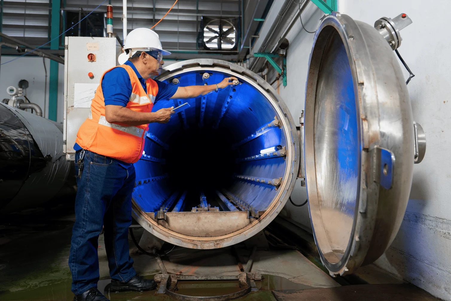 Horno de soldadura por brasado al vacío de tipo abierto, con un operador que controla los elementos dentro de la cámara.